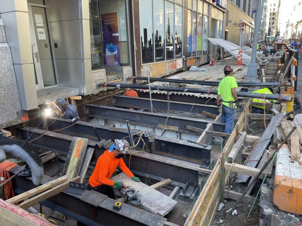 Construction Workers in Hard Hats And Reflective Vests Working on a Construction Site